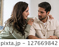 Supportive couple in emotional moment at home as woman struggles with sadness and stress, expressing 127669842