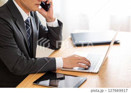 デスクでパソコン仕事をするスーツ姿のミドル男性ビジネスマン 127669917
