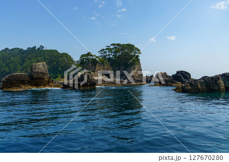 三陸海岸の岩肌と青い海と空 127670280