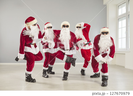 Portrait Of Happy Santas Dancing At Christmas Party 127670979