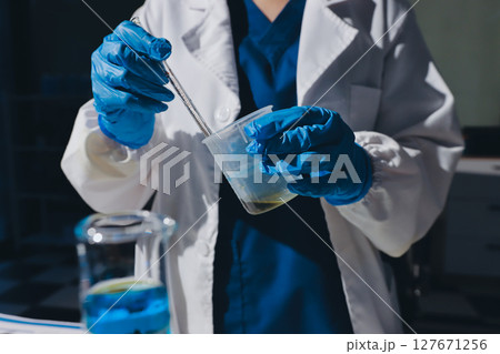 Scientist pipetting medical samples into microplate in laboratory 127671256