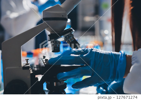 Scientist pipetting medical samples into microplate in laboratory 127671274