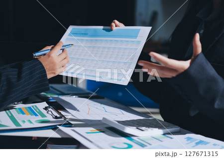 Group of business women working on a financial data expenses document. Group of business women working on a financial data expenses document. 127671315