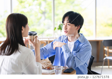 カフェでくつろぐ若い男女 127671378