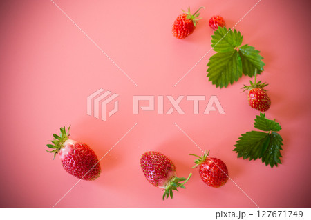 Bright juicy strawberries on a minimalist background Bright juicy strawberries on a minimalist background 127671749