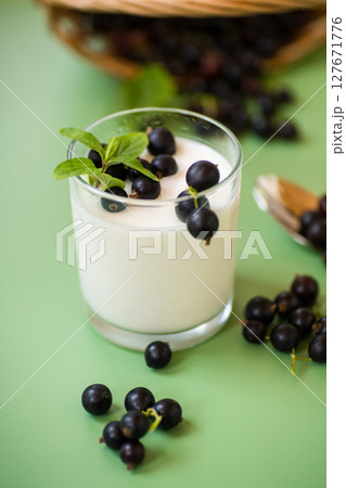 Healthy fermented milk product with berries and spoon Healthy fermented milk product with berries and spoon 127671776