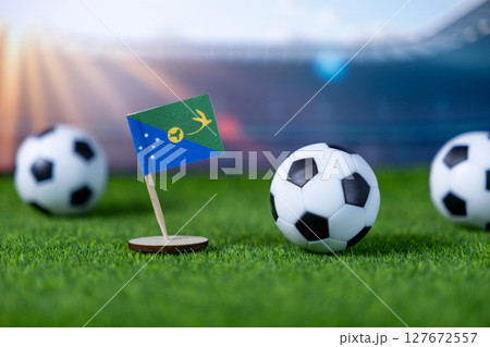 Christmas Island flag and soccer balls on green grass, symbolizing national pride, global competition, and sport passion at an international event 127672557