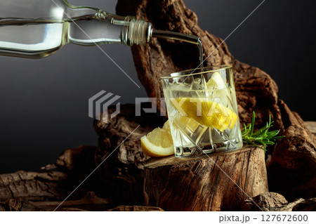 Cocktail gin and tonic with lemon slices and sprig of rosemary. Cocktail gin and tonic with lemon slices and sprig of rosemary. 127672600