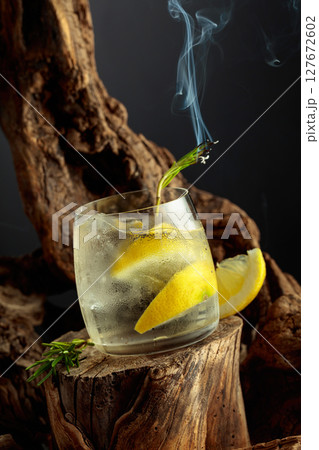 Cocktail gin and tonic with lemon slices and sprig of rosemary. 127672602