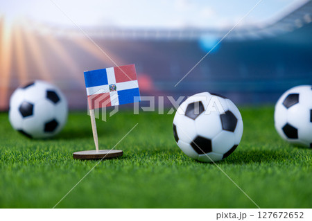 Dominican Republic flag, with soccer balls on green grass, symbolizing national team pride, athletic spirit, and international competition 127672652