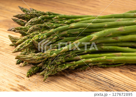 Bunch of Raw Garden Asparagus on Wood Rustic Tabletop. Fresh Green Spring Vegetables Bunch of Raw Garden Asparagus on Wood Rustic Tabletop. Fresh Green Spring Vegetables 127672895