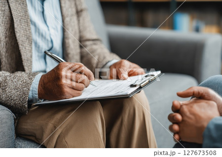 Professional psychologist engaging in therapeutic conversation with client during counseling session 127673508
