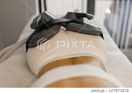 Woman getting treatment on buttocks to burn fat, build muscles and remove cellulite. Professional beauty salon 127673878