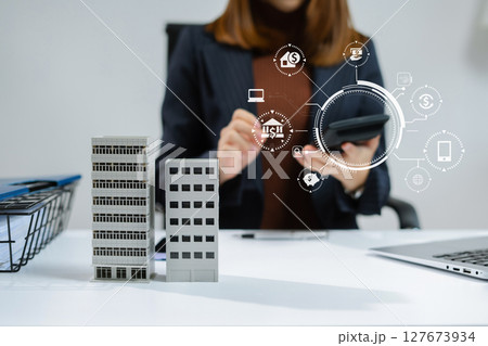 home loan officer uses a calculator with a house plan loan real estate or property. home loan officer uses a calculator with a house plan loan real estate or property. 127673934