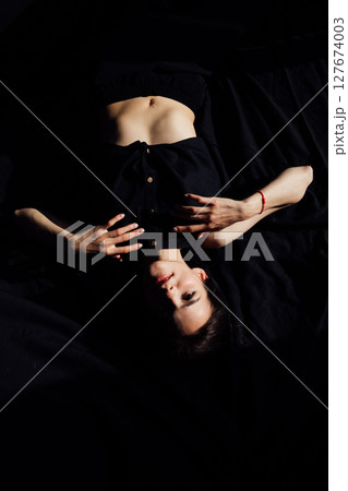 Slim woman in black lingerie in bedroom on bed before bed 127674003