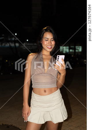Asian Woman Using Smartphone at Night in City Asian Woman Using Smartphone at Night in City 127674164