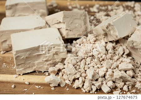 Compressed fresh yeast cubes close-up on a wooden background. Compressed fresh yeast cubes close-up on a wooden background. 127674675