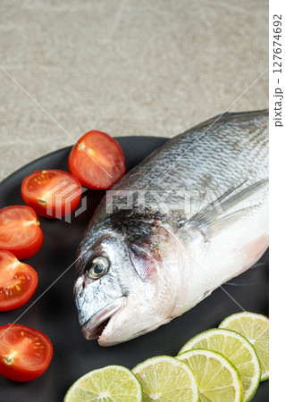 Raw Uncooked Dorado Fish with Fresh Sliced Lime Ready to Cook. 127674692