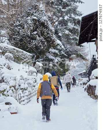 冬の中山道の観光名所馬籠宿の古い町並みの雪景色と観光客の姿 冬の中山道の観光名所馬籠宿の古い町並みの雪景色と観光客の姿 127674937