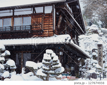 冬の中山道の観光名所馬籠宿の古い町並みの雪景色 127674938