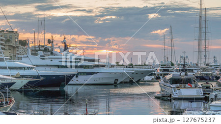 Morning view with rising sun in clouds on Harbor with yachts in parking lots in district Monte Carlo Morning view with rising sun in clouds on Harbor with yachts in parking lots in district Monte Carlo 127675237