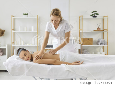 Massage female therapist doing relaxing aromatics massage oil pleasure, stimulating skin health Massage female therapist doing relaxing aromatics massage oil pleasure, stimulating skin health 127675394