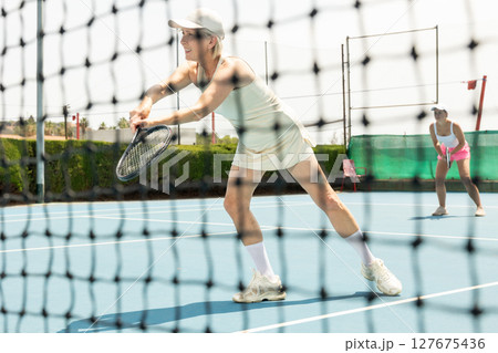 Senior woman plays tennis Senior woman plays tennis 127675436