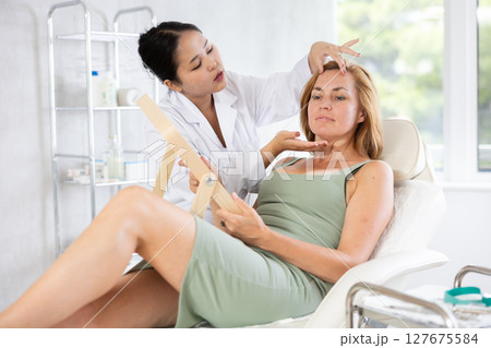 Asian doctor consulting elderly woman about procedures Asian doctor consulting elderly woman about procedures 127675584