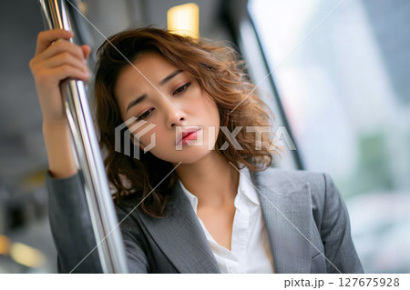 通勤電車で疲れた表情の20代日本人女性（AI生成画像） 127675928