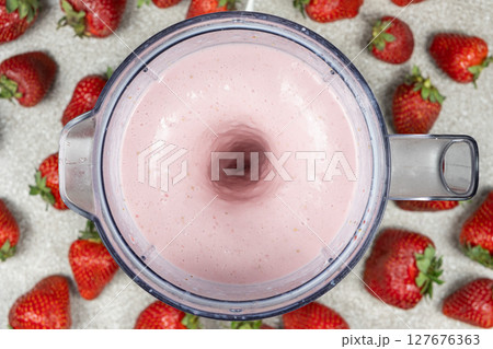 The process of making a strawberry milkshake, whisking all the ingredients in a blender. The process of making a strawberry milkshake, whisking all the ingredients in a blender. 127676363