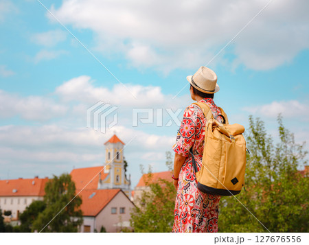 Beautiful woman walking of Varazdin streets during summer day in old, historical city center. Tourist exploring the beautiful streets, view on city from fortess 127676556