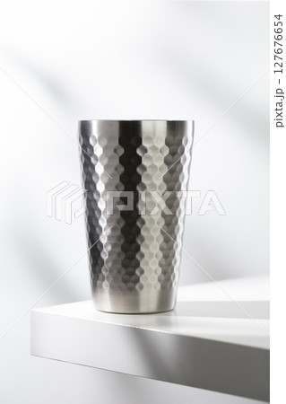 Stainless steel glass on a white table with clean, modern lighting. 127676654