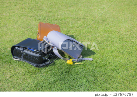 緑の芝の上に置いたランドセル 127676787