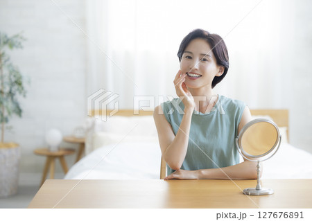 スキンケアをする寝室の女性 127676891
