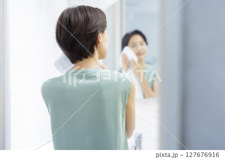 洗顔してタオルで顔を拭く女性 洗顔してタオルで顔を拭く女性 127676916