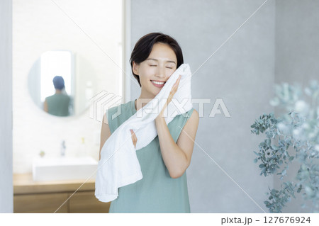 洗顔してタオルで顔を拭く女性 洗顔してタオルで顔を拭く女性 127676924