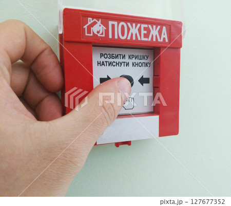hand on fire alarm button. announcement of alarm and call for help during fire hand on fire alarm button. announcement of alarm and call for help during fire 127677352