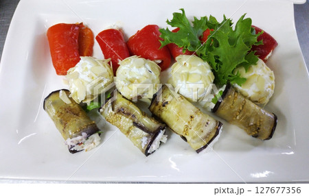 Eggplant and baked bell pepper rolls. Served with garlicky curd balls 127677356