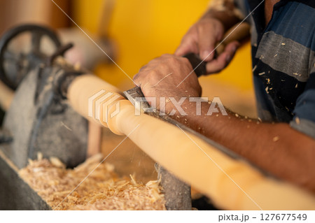 Carpenter working on wood to carving and shaping Carpenter working on wood to carving and shaping 127677549