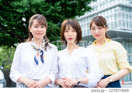 オフィスビルの前に並ぶ女性グループ 127677669