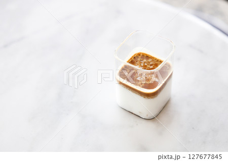 Cup of milk dirty coffee on white marble table by the window. Cup of milk dirty coffee on white marble table by the window. 127677845