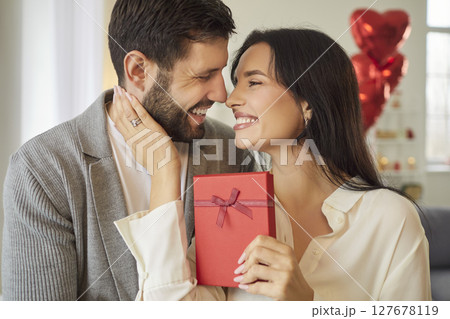 Couple Embracing With Gift Box On Valentine Day Couple Embracing With Gift Box On Valentine Day 127678119