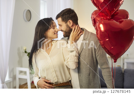 Smiling couple man and woman in love standing at home looking at each other 127678145