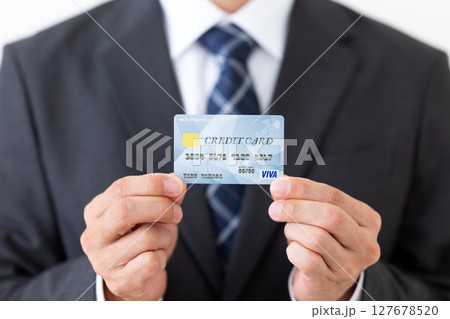 クレジットカードを持つスーツ姿のビジネスマン男性 127678520