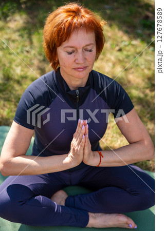 Woman meditating outdoors in a peaceful park setting during her morning routine. Mindfulness, mental balance, and emotional self-care. Woman meditating outdoors in a peaceful park setting during her morning routine. Mindfulness, mental balance, and emotional self-care. 127678589
