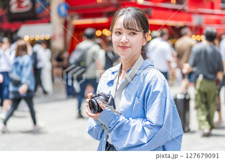 大阪の繫華街で趣味の写真撮影を楽しむ若くて可愛大阪の繫華街で趣味の写真い女性イメージ｜大阪府内で撮影 127679091