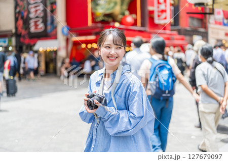 大阪の繫華街で趣味の写真撮影を楽しむ若くて可愛大阪の繫華街で趣味の写真い女性イメージ｜大阪府内で撮影 127679097