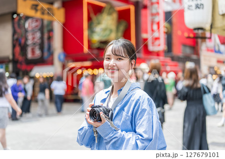 大阪の繫華街で趣味の写真撮影を楽しむ若くて可愛大阪の繫華街で趣味の写真い女性イメージ｜大阪府内で撮影 127679101