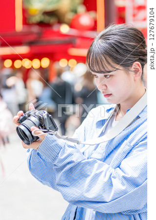 大阪の繫華街で趣味の写真撮影を楽しむ若くて可愛大阪の繫華街で趣味の写真い女性イメージ｜大阪府内で撮影 127679104