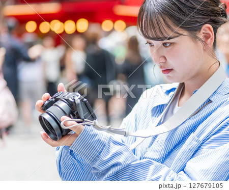 大阪の繫華街で趣味の写真撮影を楽しむ若くて可愛大阪の繫華街で趣味の写真い女性イメージ｜大阪府内で撮影 127679105